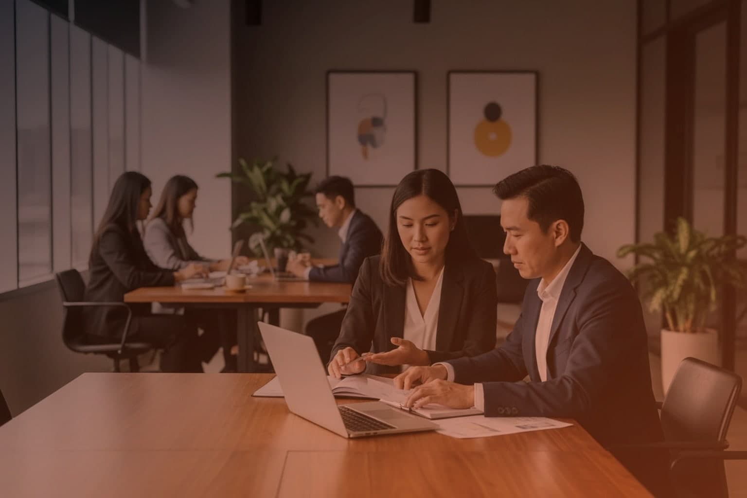 Finance leaders reviewing an ERP migration business case beside a laptop in a modern office